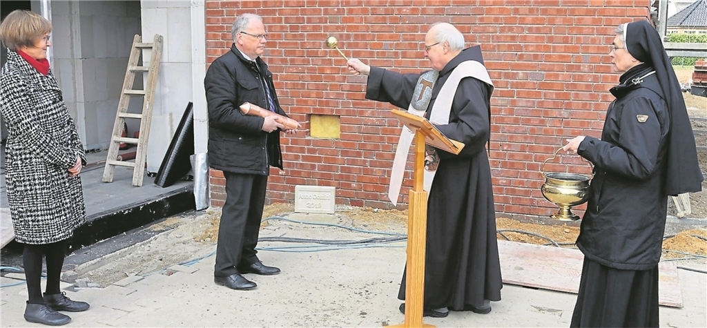 Nach dem Segnungsgottesdienst durch Pater Heinz-Günther Hilgeforth wurde die Kupferschatulle als Zeitkapsel von Heinz Mersmann, Leiter der Hauptverwaltung, eingelassen und mit dem Grundstein verschlossen. Schulleiterin Cornelia Remmers und Schwester M. Hildegard (v. l.) nehmen mit über 100 Teilnehmern an dieser Zeremonie teil. Foto: Johannes Franke